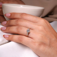 Handmade Jewelry with a round cut diamond side stone engagement ring in yellow gold.
