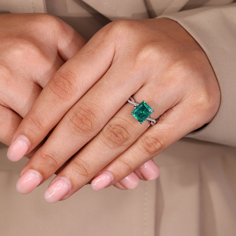 Round diamond pave band ring with emerald birthstone in white gold.
