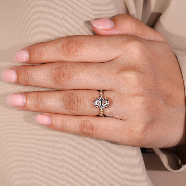 Oval hidden halo ring with round diamond pave and double claw prong setting.