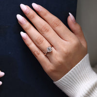 Custom diamond ring featuring round cut center and halo accents.
