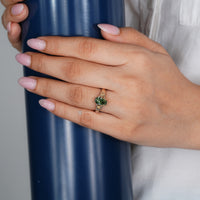 Green coffin cut diamond ring with a split shank.
