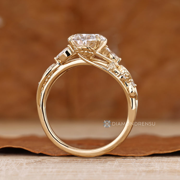 Diamondrensu presents an oval center stone with side stones.