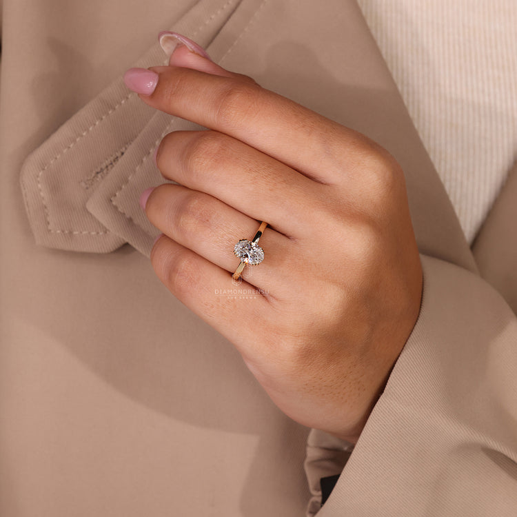 Oval engagement ring with triple prong setting and hidden diamonds.