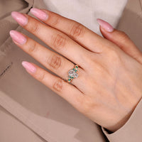 Coffin center stone ring with green emerald side details.