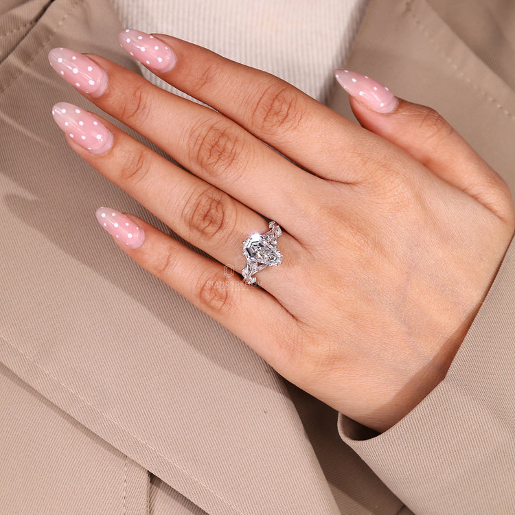 Coffin center stone ring with cluster style side stone arrangement.