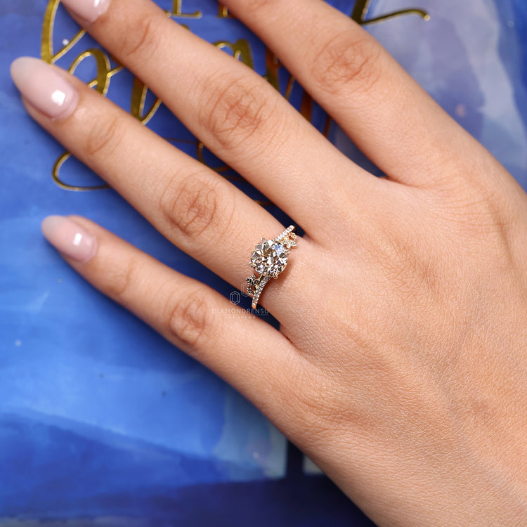 Nature inspired engagement ring with round old european cut diamond leaf details.
