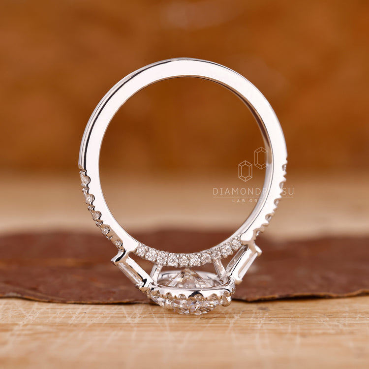 Handmade ring crafted as a three stone ring with side diamonds.
