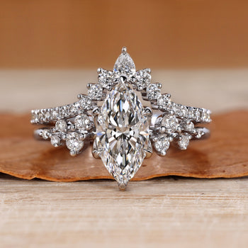 Marquise wedding ring with round side stones and prongs.