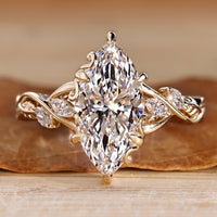 Nature inspired engagement ring with marquise center stone and marquise side stones.