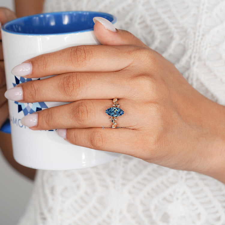 Blue marquise engagement ring with a tulip setting.