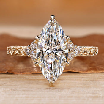Art Deco diamond ring with marquise center stone and round side stones.