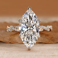 Marquise engagement ring with twisted shank and round accents.