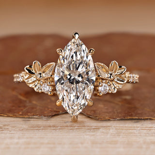Marquise cut engagement ring with flower design and side stones.