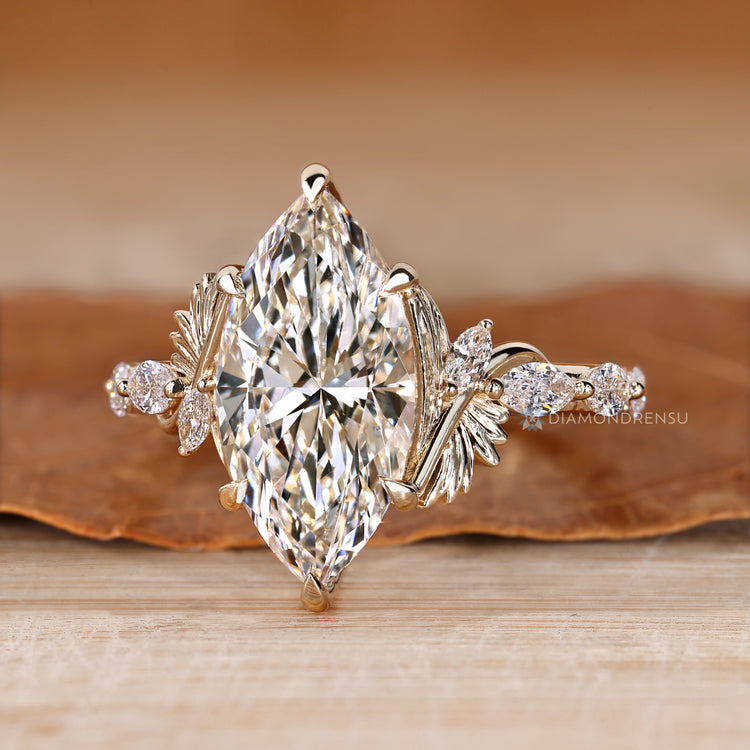 Six claw prong setting secures the marquise center stone.