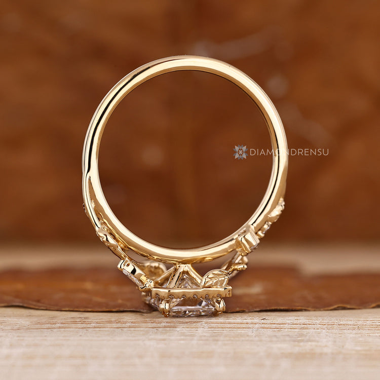 Radiant cut ring with round diamond halo and prong setting.