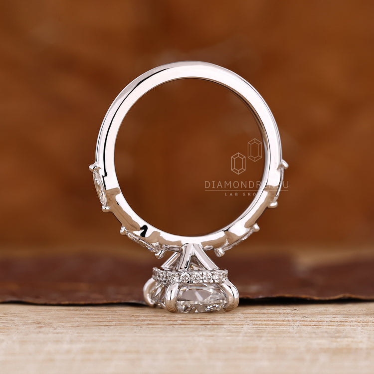 Handmade elongated cushion cut diamond ring with marquise and round cut details.