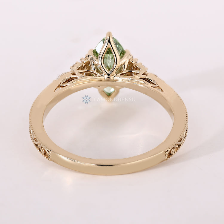 Green marquise diamond ring with a six claw prong setting.
