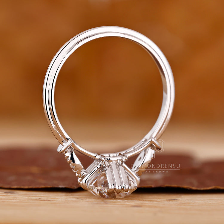 Cushion old mine cut diamond with milgrain edge and side stones.
