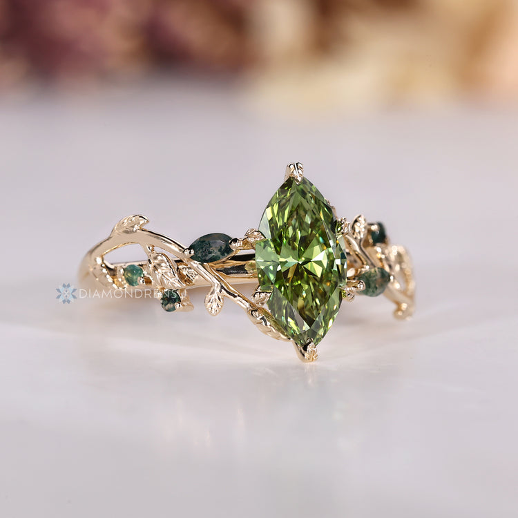 Green marquise engagement ring with cathedral setting.