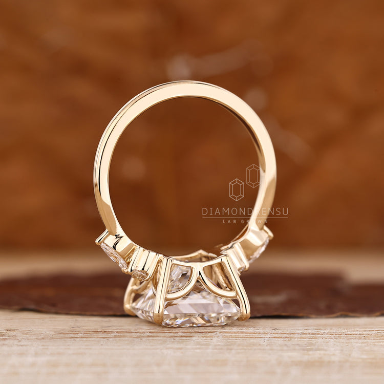 Princess cut diamond ring with marquise and round side stones.
