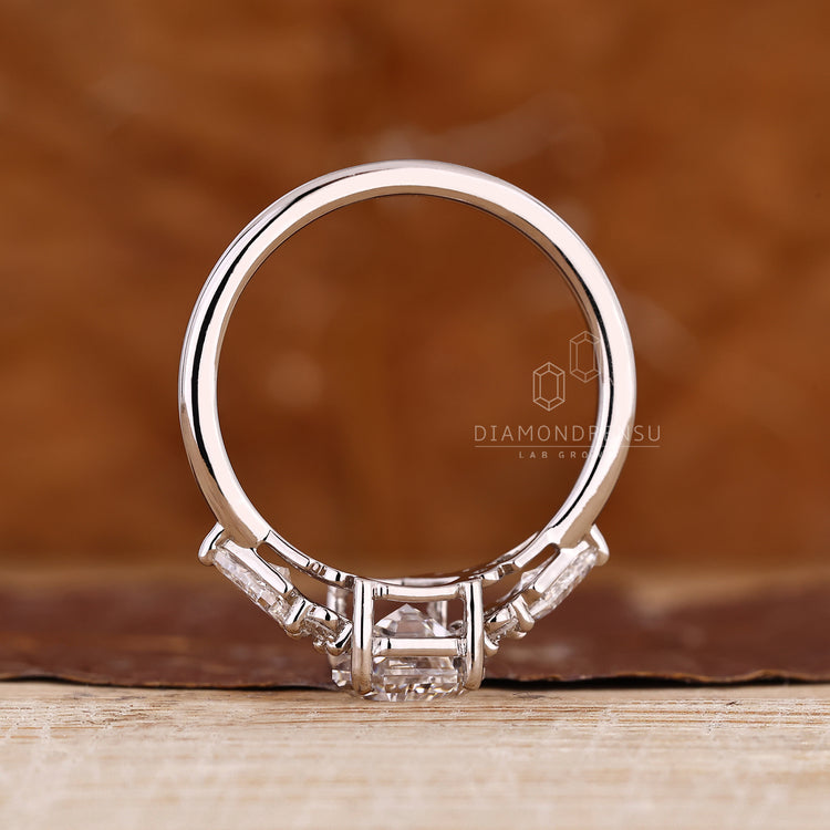 Coffin diamond ring with four prong setting and side stones.