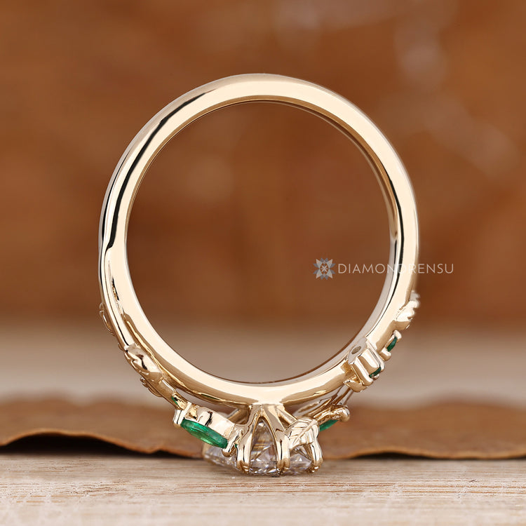 Nature inspired engagement ring with marquise and round side stones.