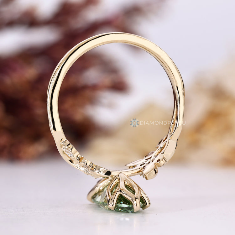 Green marquise center stone with round stones.