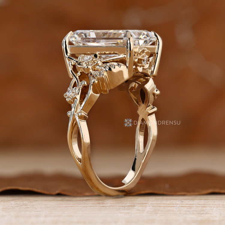 Radiant engagement ring with round side stones and a twisted shank.