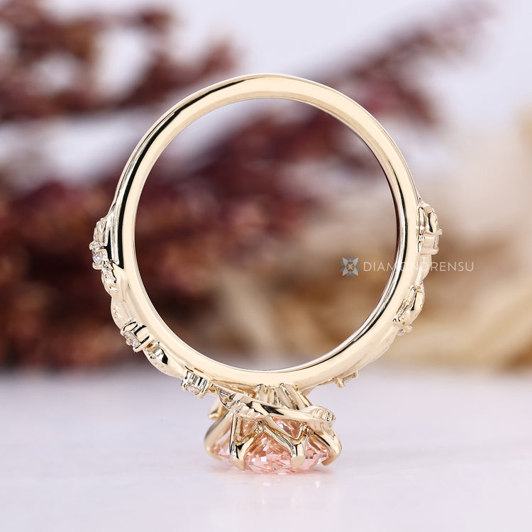 Pink oval engagement ring with six claw prong setting.