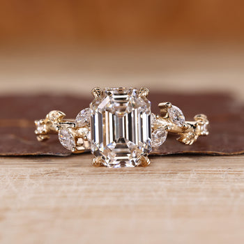 Nature inspired engagement ring with emerald old european cut diamond center.
