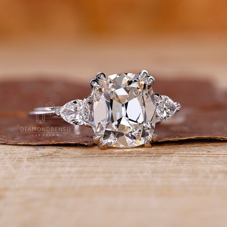 Elegant engagement ring with cushion old mine center and pear sides.