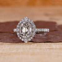 Cushion old mine diamond ring with double claw prong and halo setting.
