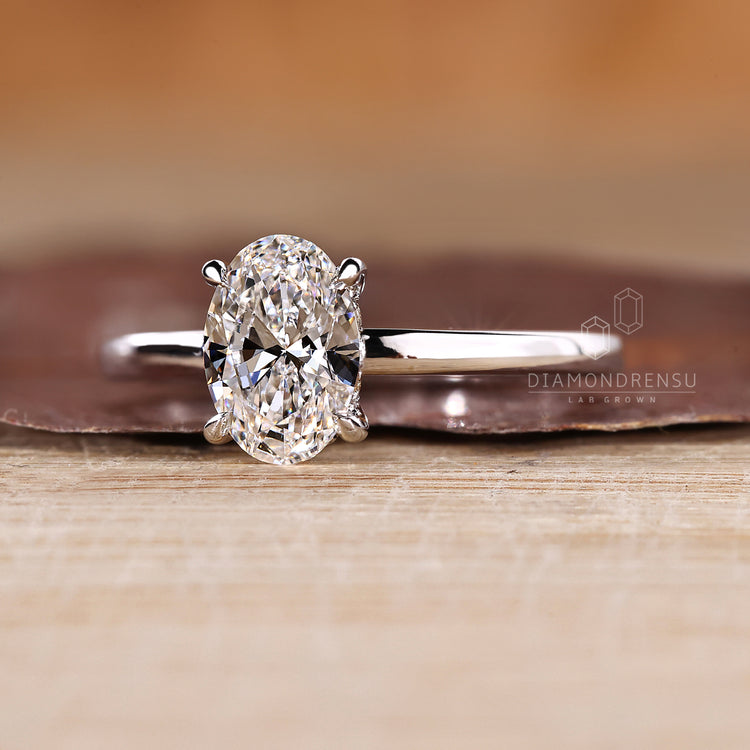 Oval diamond ring with hidden halo and solitaire design.