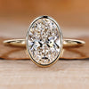 Bezel engagement ring with an oval cut diamond.