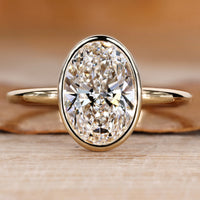 Bezel engagement ring with an oval cut diamond.