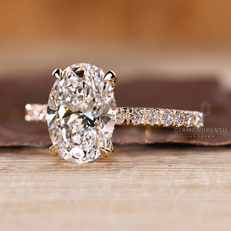 Oval cut engagement ring with round cut hidden halo and side stones.