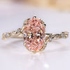 Oval engagement ring with pink center diamond and round side stones.