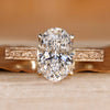 Art Deco engagement ring with oval center stone and milgrain details.