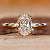 Solitaire engagement ring with oval cut diamond and triple prong setting.
