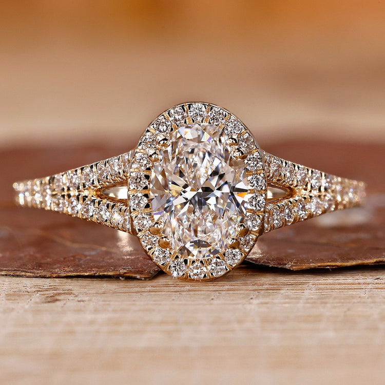 Oval diamond engagement ring with round cut halo style and split shank.