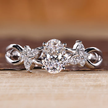 Oval diamond engagement ring with nature inspired design and cluster diamond center.
