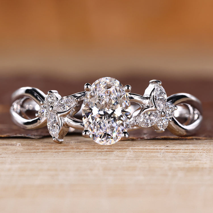 Oval diamond engagement ring with nature inspired design and cluster diamond center.
