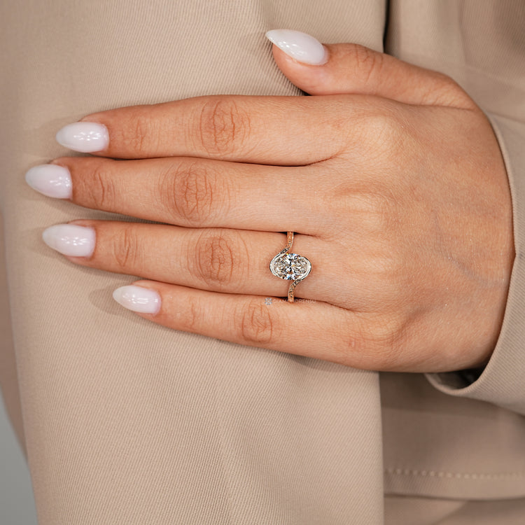Oval Art Deco diamond ring with a bypass setting and milgrain details.