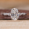 Oval cut diamond ring with seven stones including pear and round side stones.
