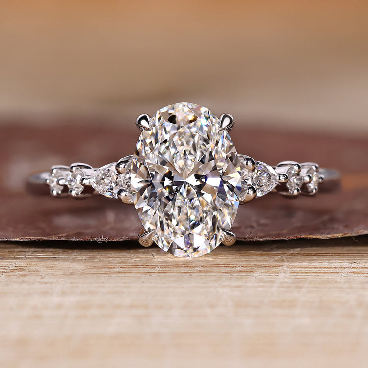 Oval cut diamond ring with seven stones including pear and round side stones.