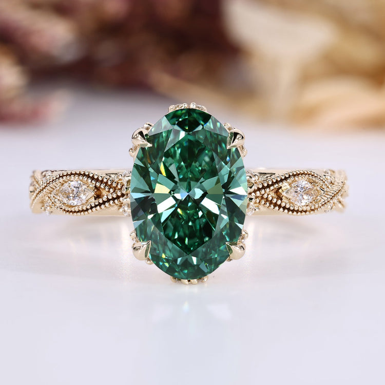Oval cut diamond ring with green center stone and round side stones.