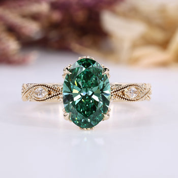 Oval cut diamond ring with green center stone and round side stones.