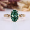 Oval cut diamond ring with green center stone and round side stones.
