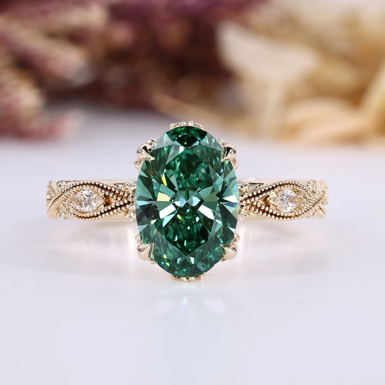 Oval cut diamond ring with green center stone and round side stones.