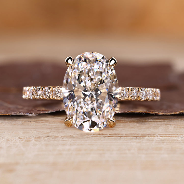 Oval cut diamond ring with round cut pave band and hidden halo setting.